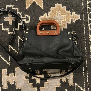 Black Madison West purse with wooden handles and crossbody strap